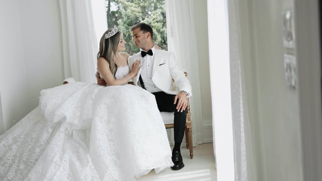 Bride and groom by a bright windowsill in a featured wedding film