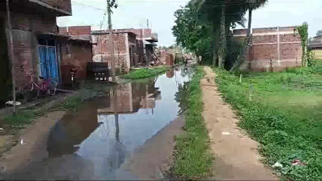 नाले की बदबूदार पानी के बीच गुजरने को विवश हैं ग्रामीण 