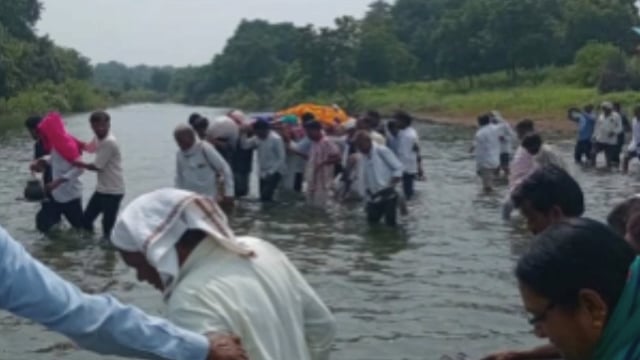 स्मशान भूमीला जाण्यासाठी रस्ता नसल्याने नदीच्या पाण्यातून अंत्यसंस्कार करण्यासाठी नागरिकांची कसरत