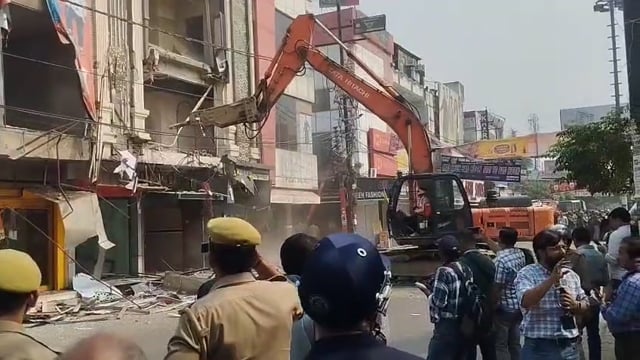 मेरठ:-
 शास्त्रीनगर सेंट्रल मार्किट में बने 35 साल पुराने अवैध कांप्लेक्स में बनीं 22 दुकानों को तोड़ने का काम हुआ शुरू। सुप्रीम कोर्ट के आदेश पर शुरू हुआ एक्शन। प्रशासन के बुलडोजर एक्शन से पहले कारोबारी अपनी दुकानों के सामने बैठकर फूट-फूटकर रोने लगे। उन्होंने कहा कि अब उनका क्या होगा, कहां जाएंगे और किस तरह से अपना गुजारा करेंगे। भारी फोर्स के साथ PAC और ATS के ड्रोन से निगरानी,