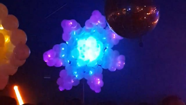 Float of Thin Air performing with a gradient flower balloon at Thuishaven in Amsterdam