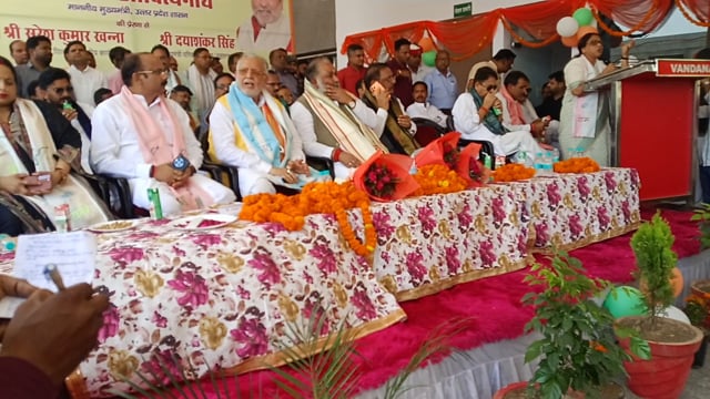 सभी लोग मंच पर उपस्थित अर्चना वर्मा संबोधित करती हुई