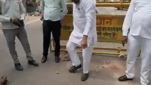 आगरा में समाजवादी पार्टी के नेता नितिन कोहली सड़क पर हुए गड्ढे में माल ढूंढ रहे हैं वह गड्ढे के पास बैठ जाते हैं और चारो