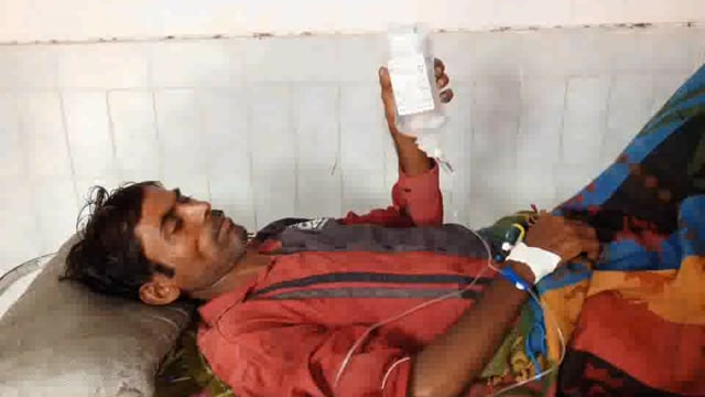 माधव प्रसाद त्रिपाठी मेडिकल कॉलेज में मरीज द्वारा स्ट्रेचर पर लेटकर ग्लूकोज की बोतल को हाथ में लिए व्यक्ति का फोटो हो रह