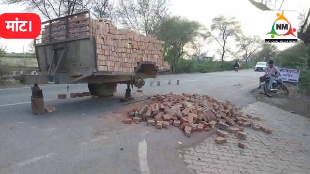 राधारानी मंदिर के समीप ईंटों से भरी ओवरलोडिंग ट्रॉली का फटा टायर, सड़क पर बिखरीं ईंटें।