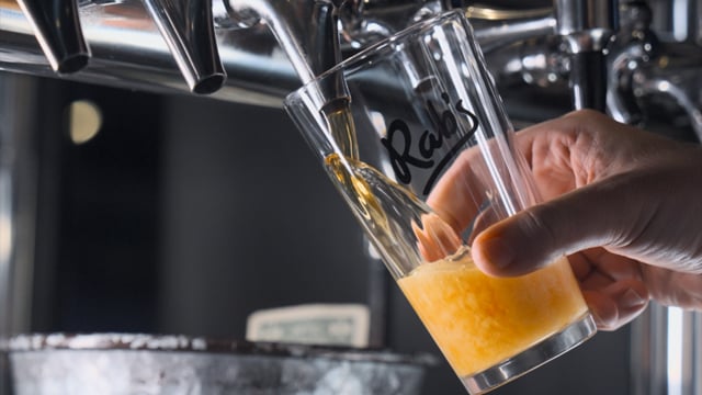 High-speed beverage cinematography showing beer pouring with condensation and tabletop motion control