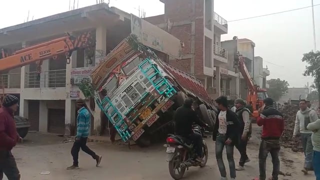 शमशाबाद रोड स्थित मारुति सिटी के सामने बालू से भरा ट्रक सड़क धसने से पलटा