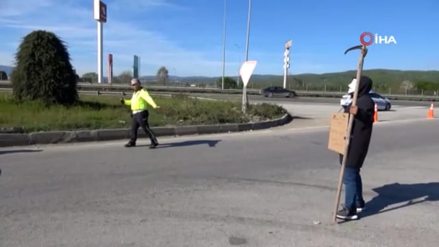 Yüzüne maske takıp, eline tırpan aldı: TEM’de sürücüleri böyle uyardı